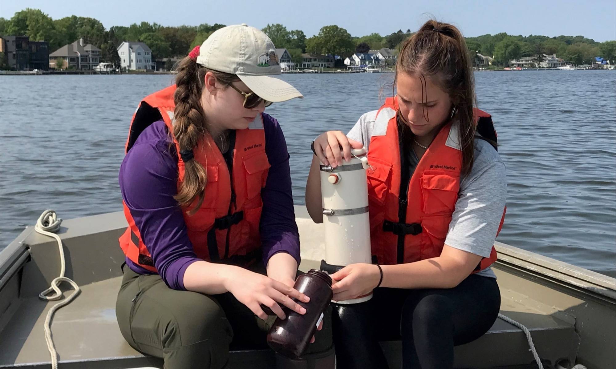 Two students collect water from a VanDorn sampler.